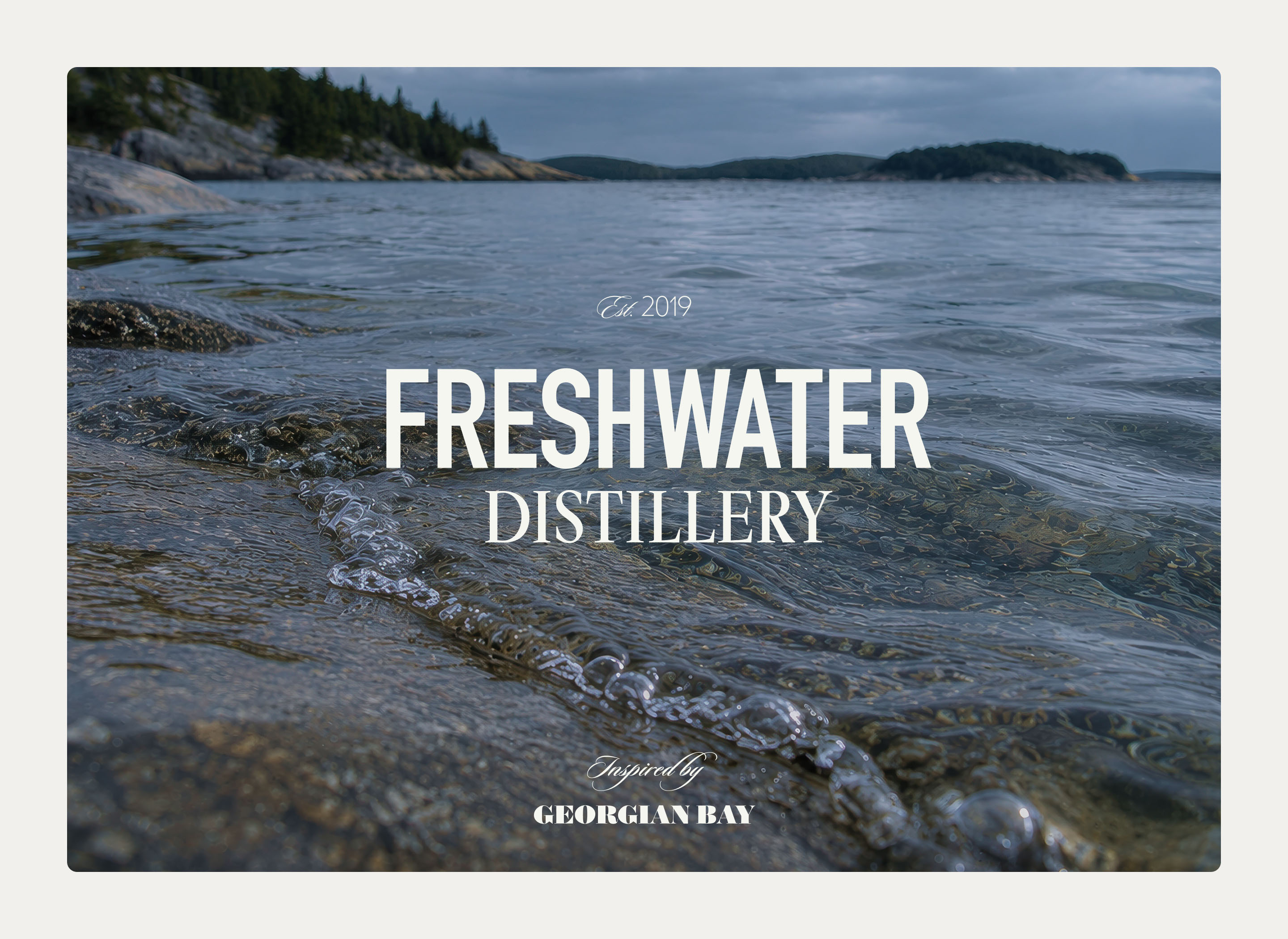 Freshwater Distillery wordmark over a photograph of Georgian Bay shoreline and clear freshwater.