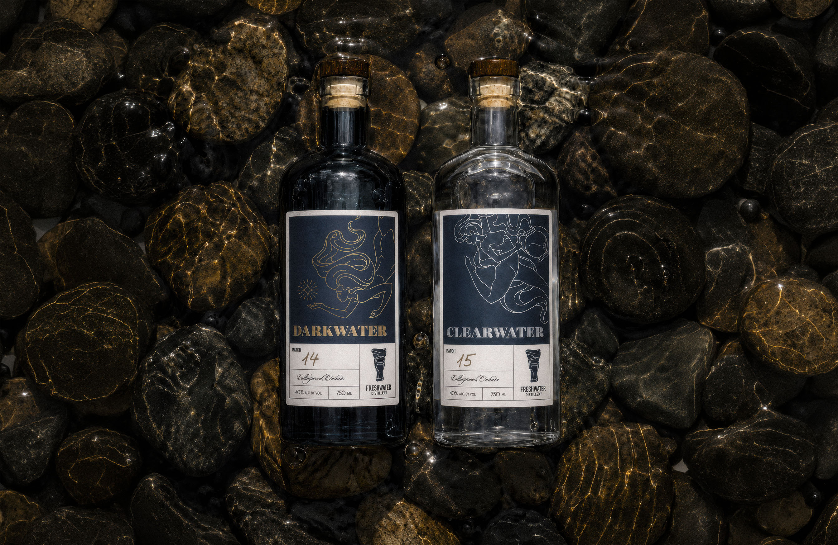 Darkwater and Clearwater spirit bottles resting among wet stones, featuring illustrated Freshwater Distillery labels.