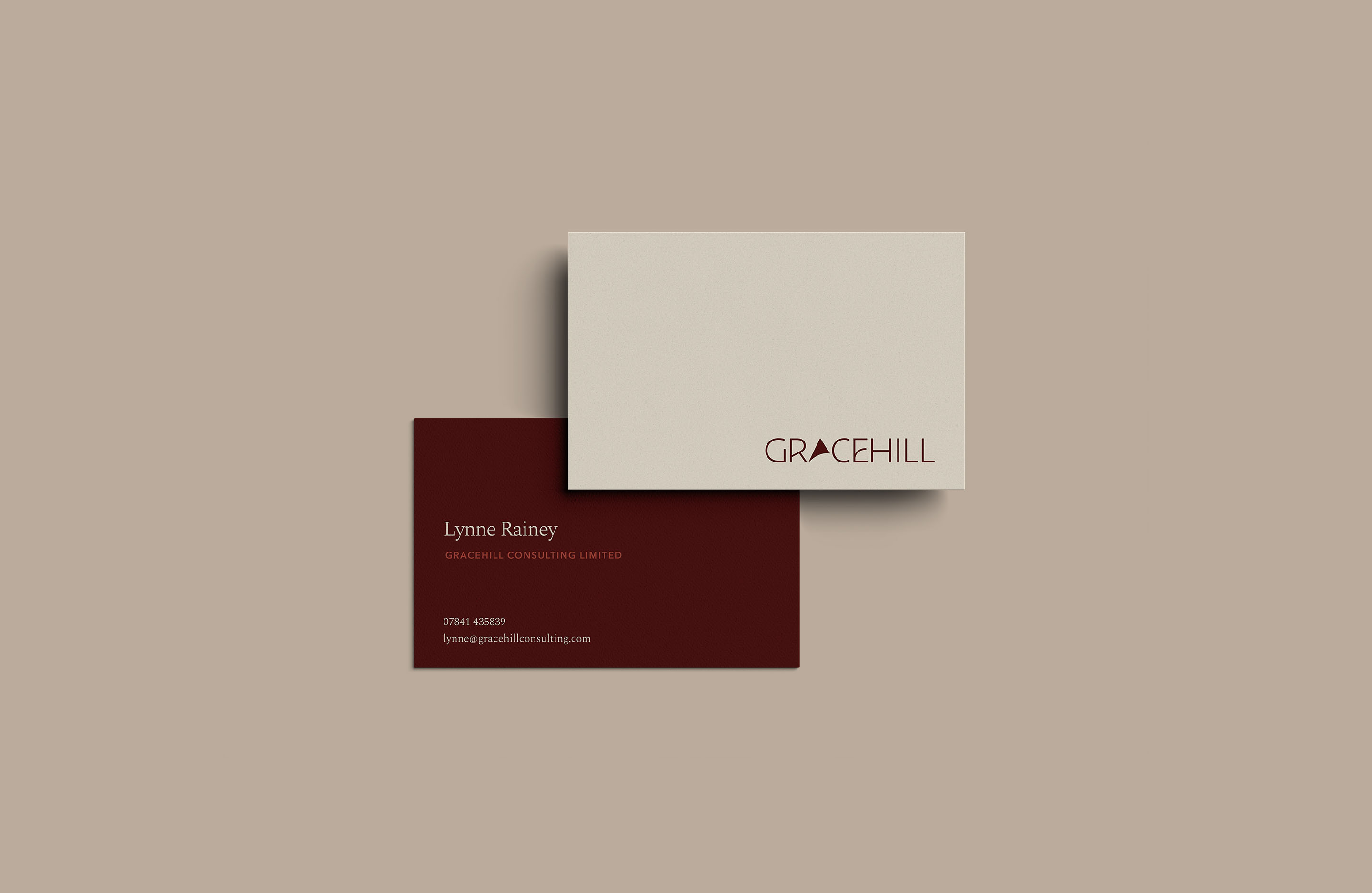 Gracehill Consulting business cards featuring the wordmark and cream and burgundy colour palette.