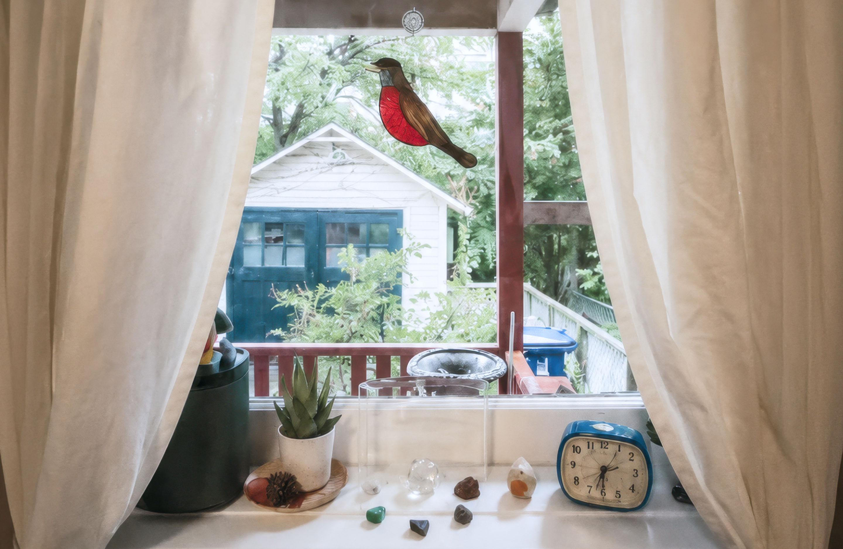 Mike Fuhr treatment space featuring a window overlooking a garden and an American robin stained glass decoration.
