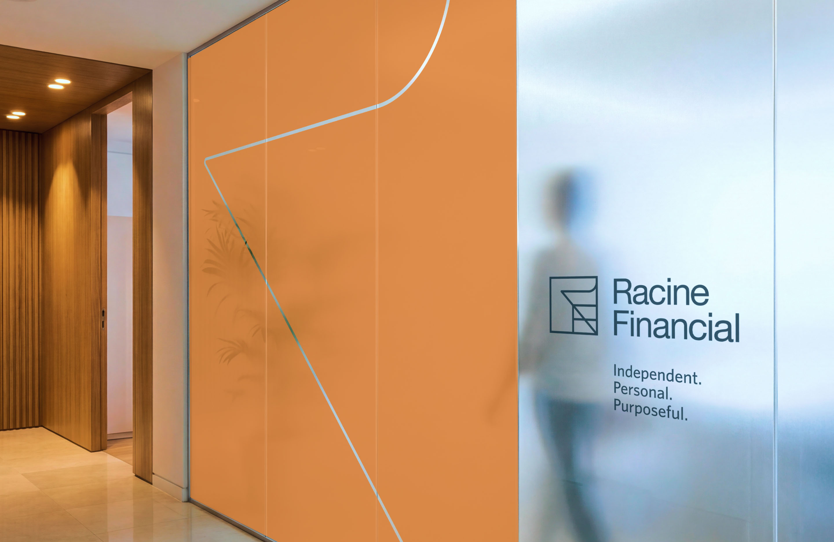 Racine Financial office signage featuring the geometric brand identity on orange and glass surfaces.